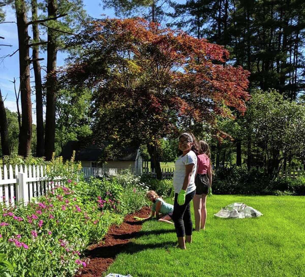 New Milford Girl Scouts from Troops 40206 and 40074 recently donated flats of fresh flowers and $150 worth of mulch and helped beautify the gated garden at Harrybrooke Park in New Milford with the park's lead gardener, Michelle Gentile.