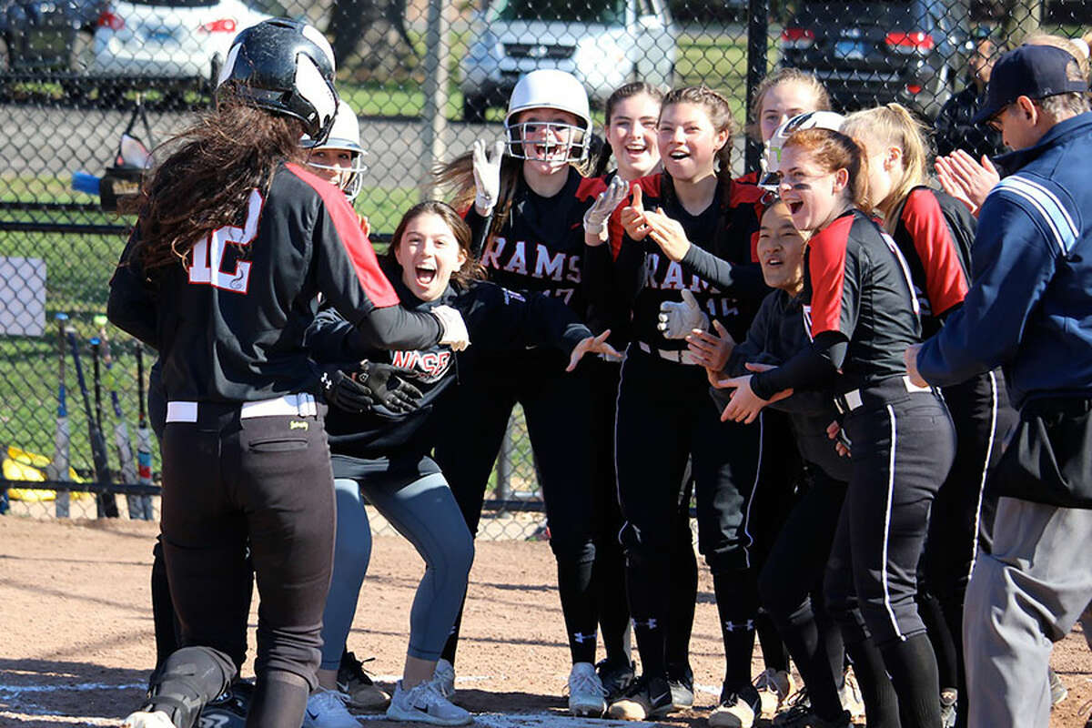 The New Canaan Rams greet senior Kara Fahey at home plate after one of her two home runs during a 15-2 win over Bridgeport Central in Waveny Park on Tuesday. — Terry Dinan photo