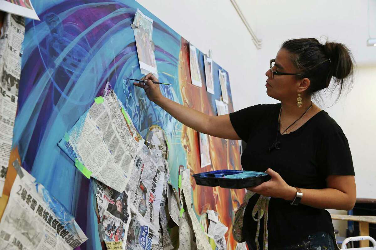 Local artist Adriana M. Garcia leads students and volunteers Tuesday as they work on a mural depicting non-traditional students at the Palmetto Center for the Arts at Northwest Vista College. The mural is under the Mexican-American Studies Art Project and funded by the National Endowment for the Arts and Northwest Vista College.