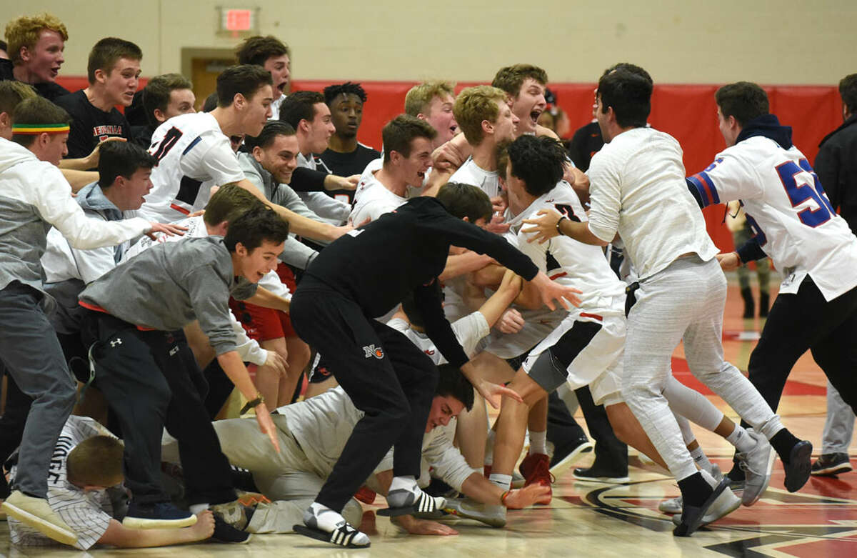 The New Canaan Rams and some of their fans celebrate on the court after beating Stamford 52-49 at New Canaan High School on Thursday, Jan. 10. — Dave Stewart/Hearst Connecticut Media