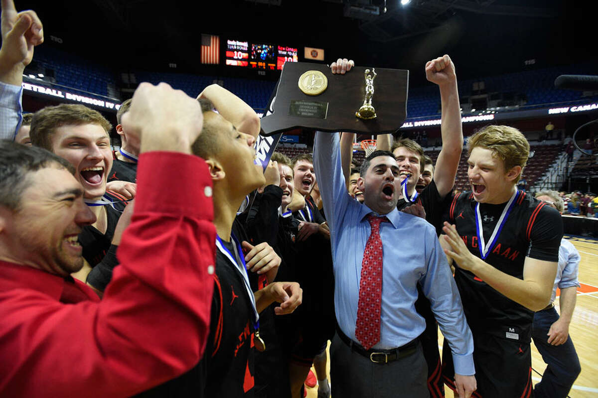 New Canaan head coach Danny Melzer holds up the championship plaque with his players after defeating Granby 55-39 in the CIAC Div. IV final at Mohegan Sun Arena on Saturday, March 16. — Matt Brown/Hearst Connecticut Media