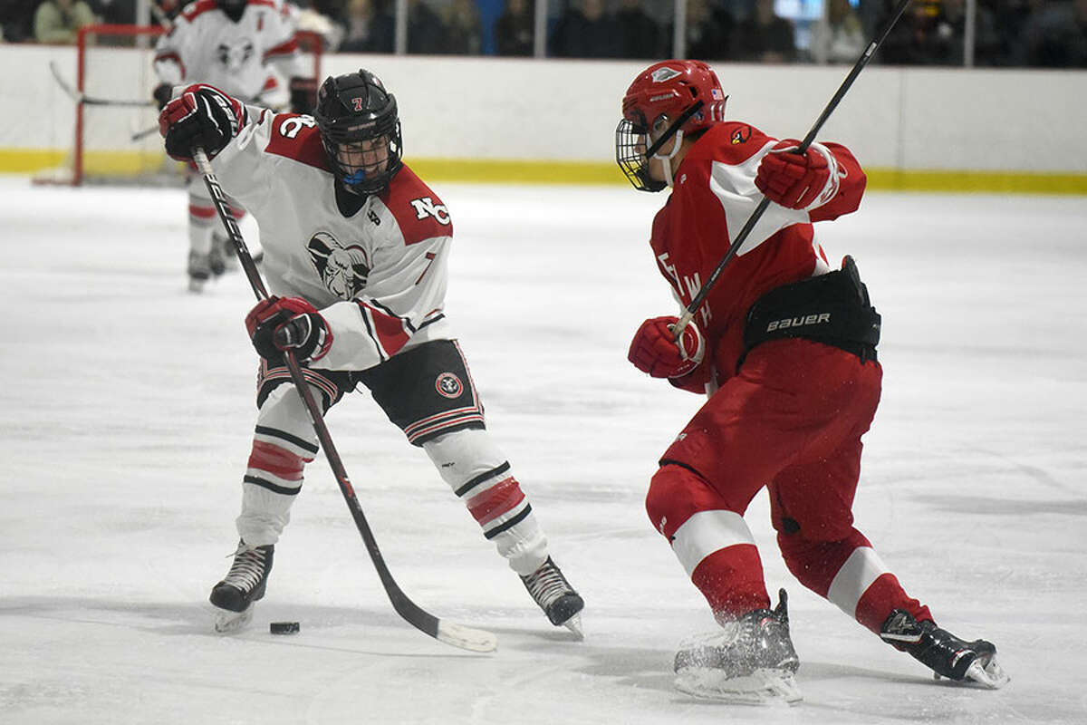New Canaan’s Brendan Knightly (7) and Greenwich’s Dylan Madden (11) battle for the puck during the first round of the CIAC Div. I tournament on Tuesday, March 5, at the Darien Ice House. — Dave Stewart/Hearst Connecticut Media
