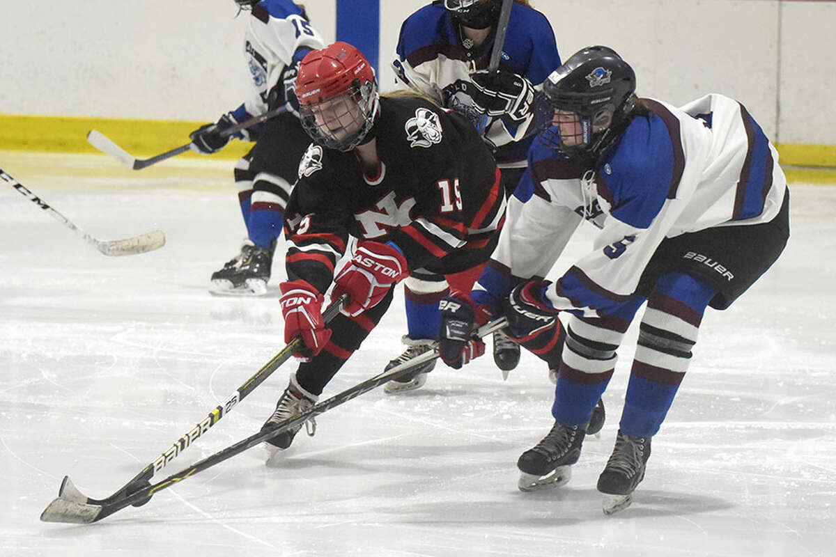 New Canaan's Caitlin Tully (15) and Suffield's Sydney Eitel (5) battle for the puck during the state quarterfinals Saturday at the Darien Ice House. — Dave Stewart Hearst Connecticut Media