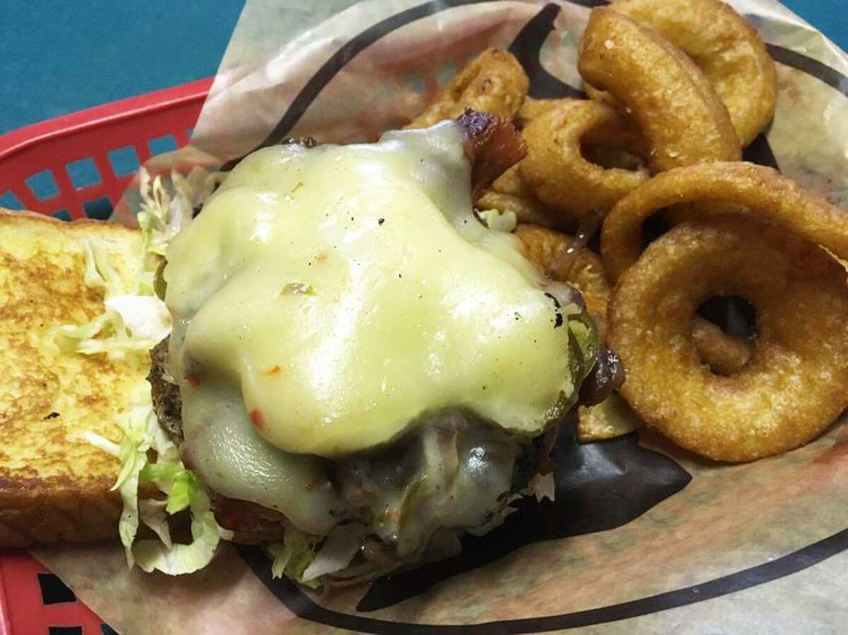 The CB's Spicy Burger, served with onion rings, comes with caramelized onions, Tabasco, grilled jalapeños, bacon, pepper Jack cheese and a Sriracha mayo.