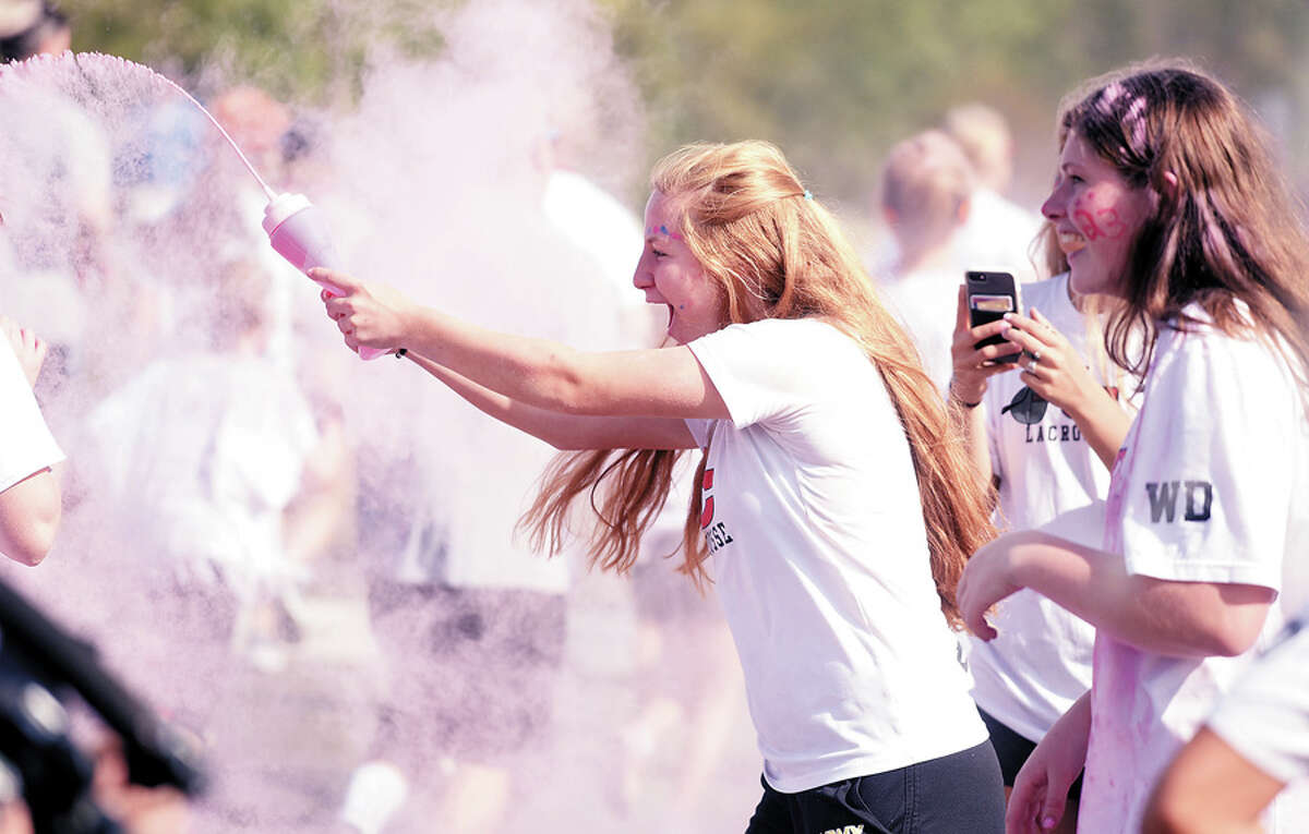 New Canaan High School junior Gianna Bruno sprays color powder during the first New Canaan Color Run April 29, 2017 at the school. More than 1,200 people participated in the event, with proceeds going towards college scholarships for this year’s NCHS graduates via the NCHS Scholarship Foundation.