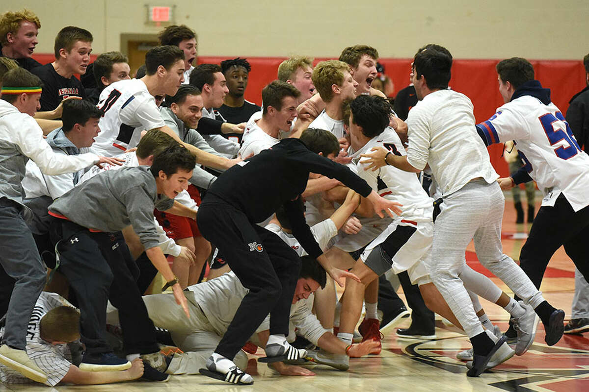 The New Canaan Rams and some of their fans celebrate on the court after the boys basketball team defeated Stamford 52-49 at New Canaan High School on Thursday, Jan. 10. — Dave Stewart/Hearst Connecticut Media photo