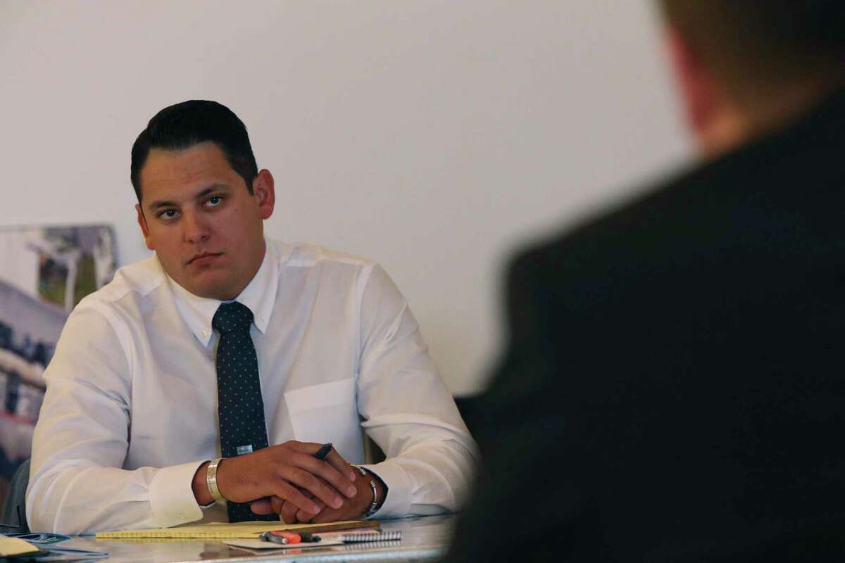 Fired San Antonio Police Officer Justin Ayars looks at attorney Logan Lewis, who represents the city of San Antonio, during opening statements in his arbitration hearing June 25, 2019.