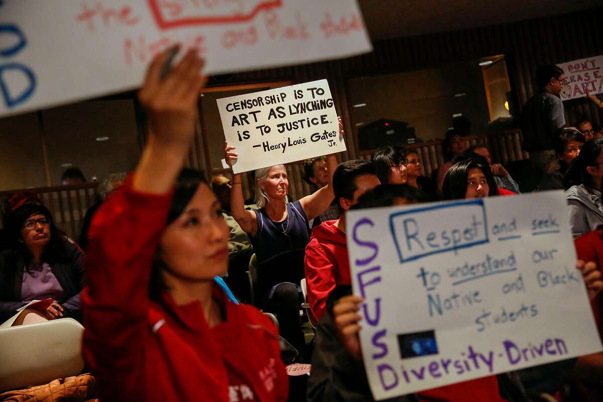 Carol Denney holds up a sign supporting controversial mural at George Washington High School during the San Francisco Unified School District school board meeting Tuesday, June 25, 2019, in San Francisco, Calif.