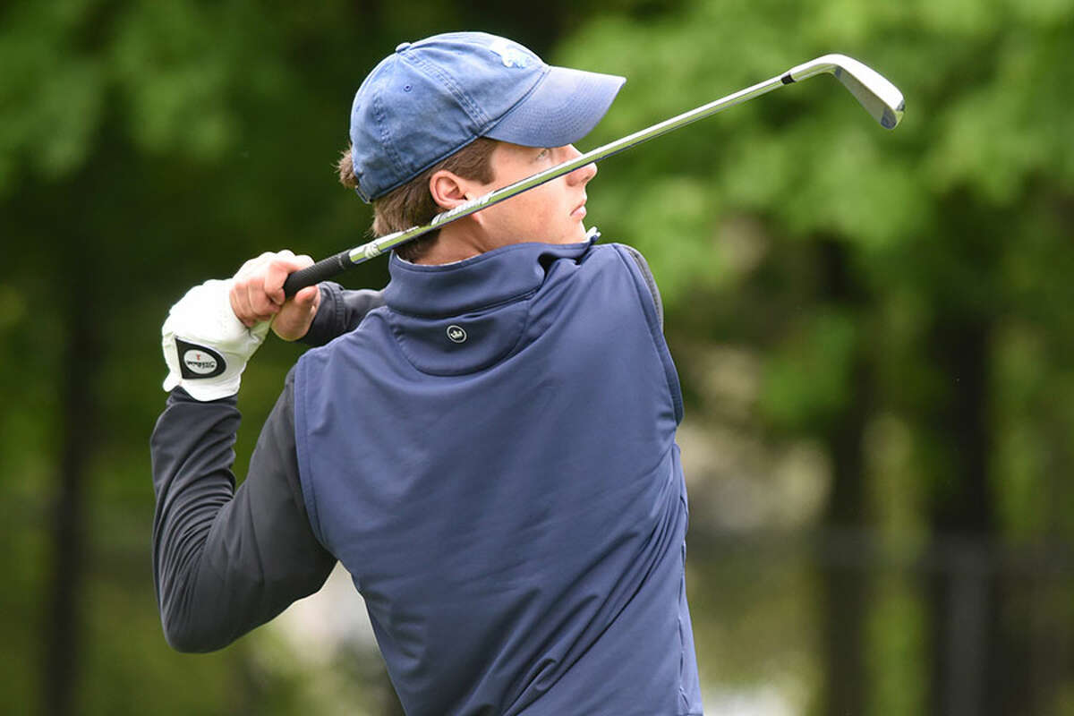 Darien's Calvin Smith follows the flight of the ball during the Blue Wave's boys golf match against Trinity Catholic at Sterling Farms GC in Stamford on Tuesday - Dave Stewart/Hearst Connecticut Media