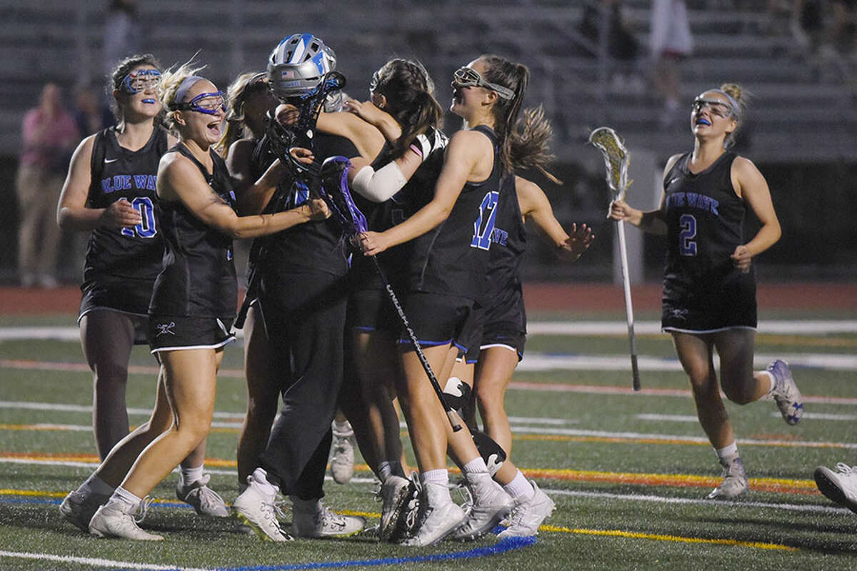The Darien Blue Wave celebrates after defeating New Canaan 12-7 for the FCIAC girls lacrosse championship at Testa Field in Norwalk on Wednesday, May 22, 2019. — Dave Stewart/Hearst Connecticut Media