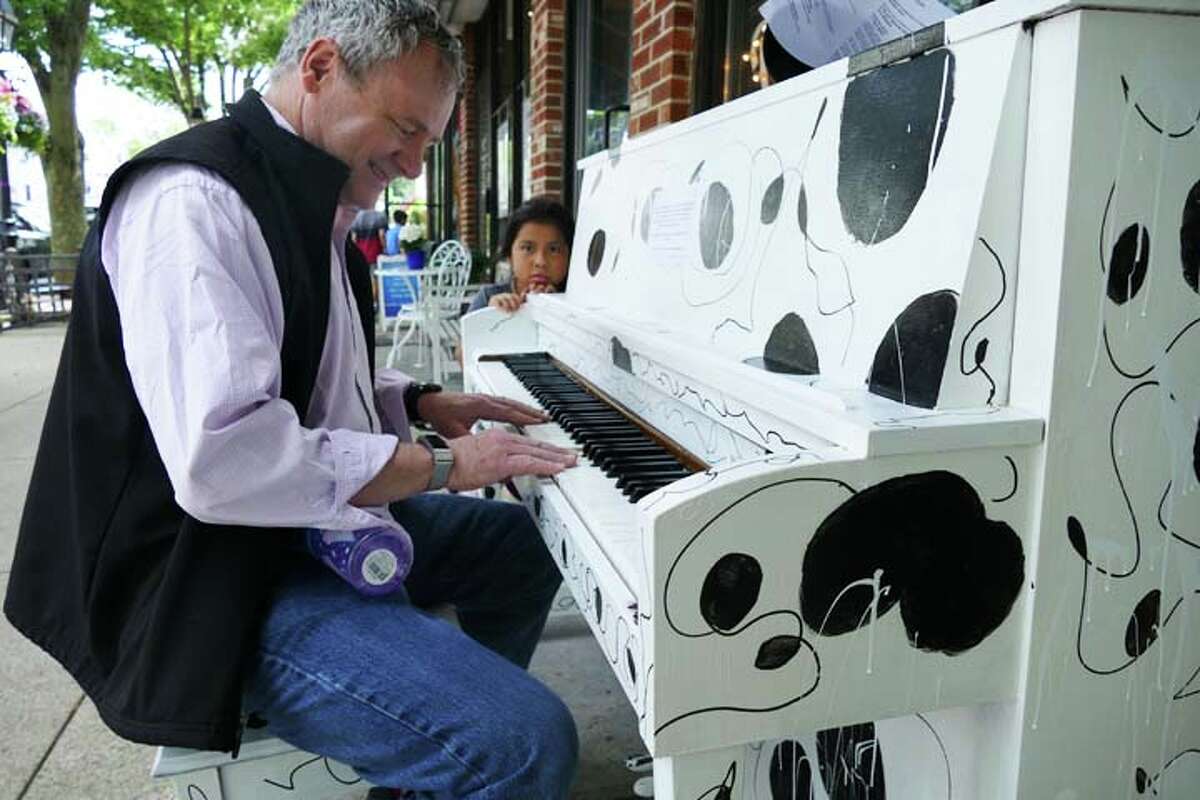 Chris Conroy plays the piano for his daughter, Anna, outside of Kafo on Main Street during Make Music Day, June 21. — Steve Coulter photo