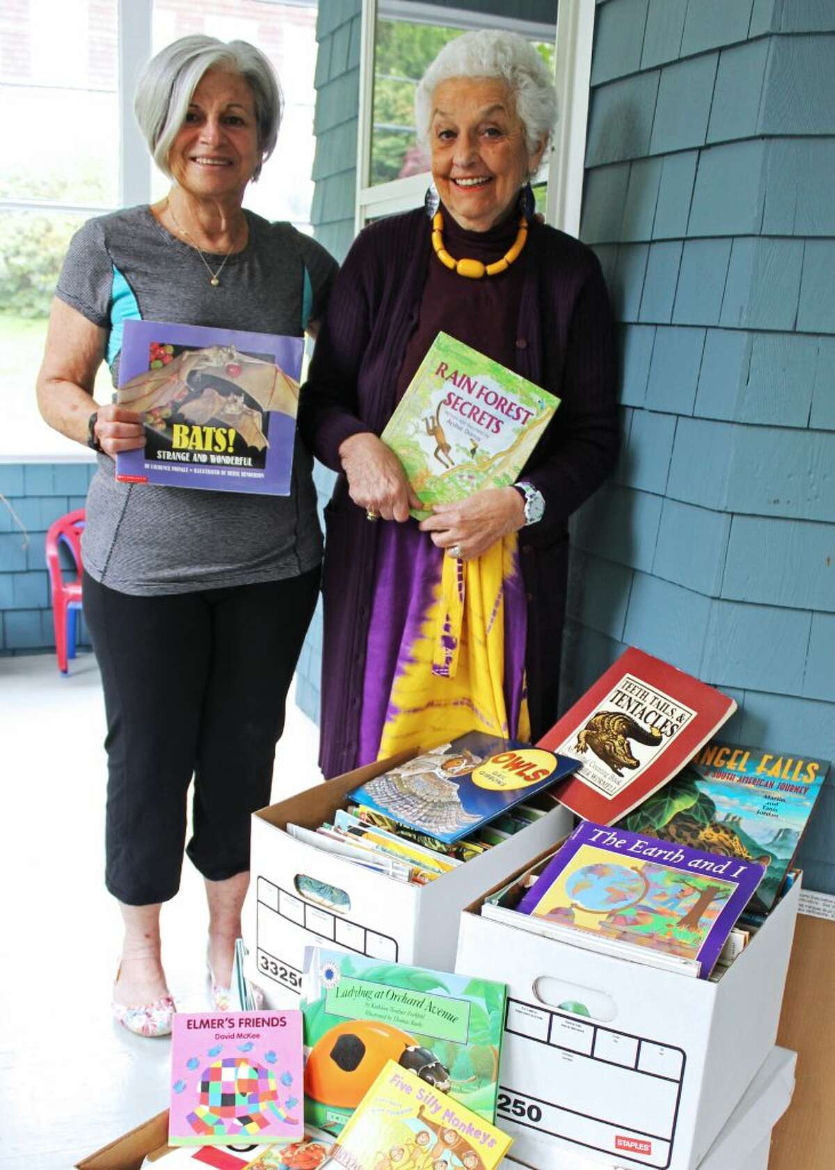 Professor Emerita of Social Work Dr. Patti Ivry and Professor Emerita of Education Dr. Darla Shaw with some of the books Shaw donated to the Impact Network to promote literacy in Zambia.