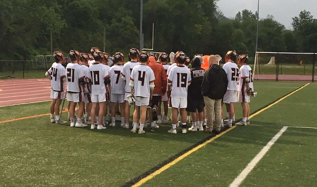 Ridgefield players gather around head coach Roy Colsey after Wednesday's 16-4 win over Trumbull in the Class L tournament. - Tim Murphy / Hearst Connecticut Media