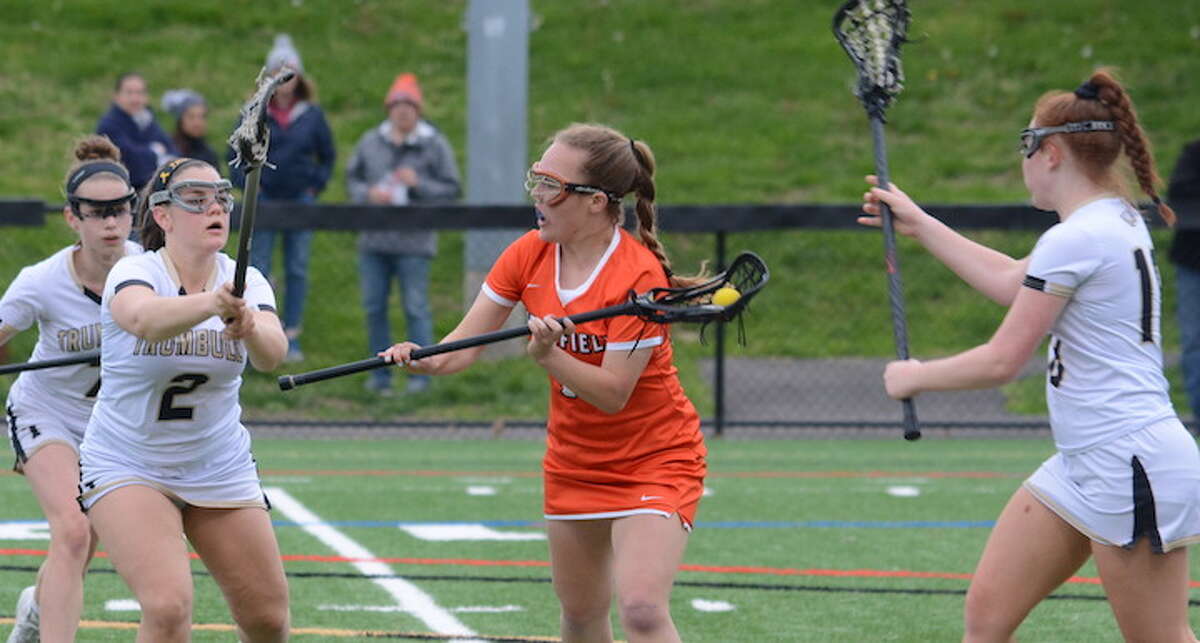 Maddie McGrath draws a crowd of Trumbull players during Thursday's girls lacrosse game. - Andy Hutchison photo