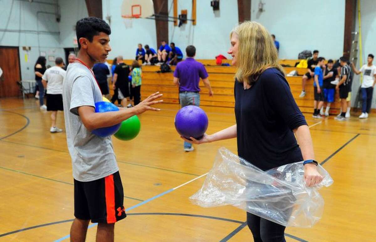 Melissa McGarry hands out dodgeballs to players taking part in TPAUD's Dodge-a-Cop Dodgeball Tournament at Hillcrest Middle School. — Hearst CT Media