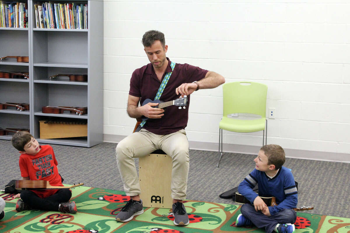 Miller-Driscoll music teacher Chris Johnson tunes a students ukulele. Taken Wednesday May 1 at Miller-Driscoll School. - Lynandro Simmons photo