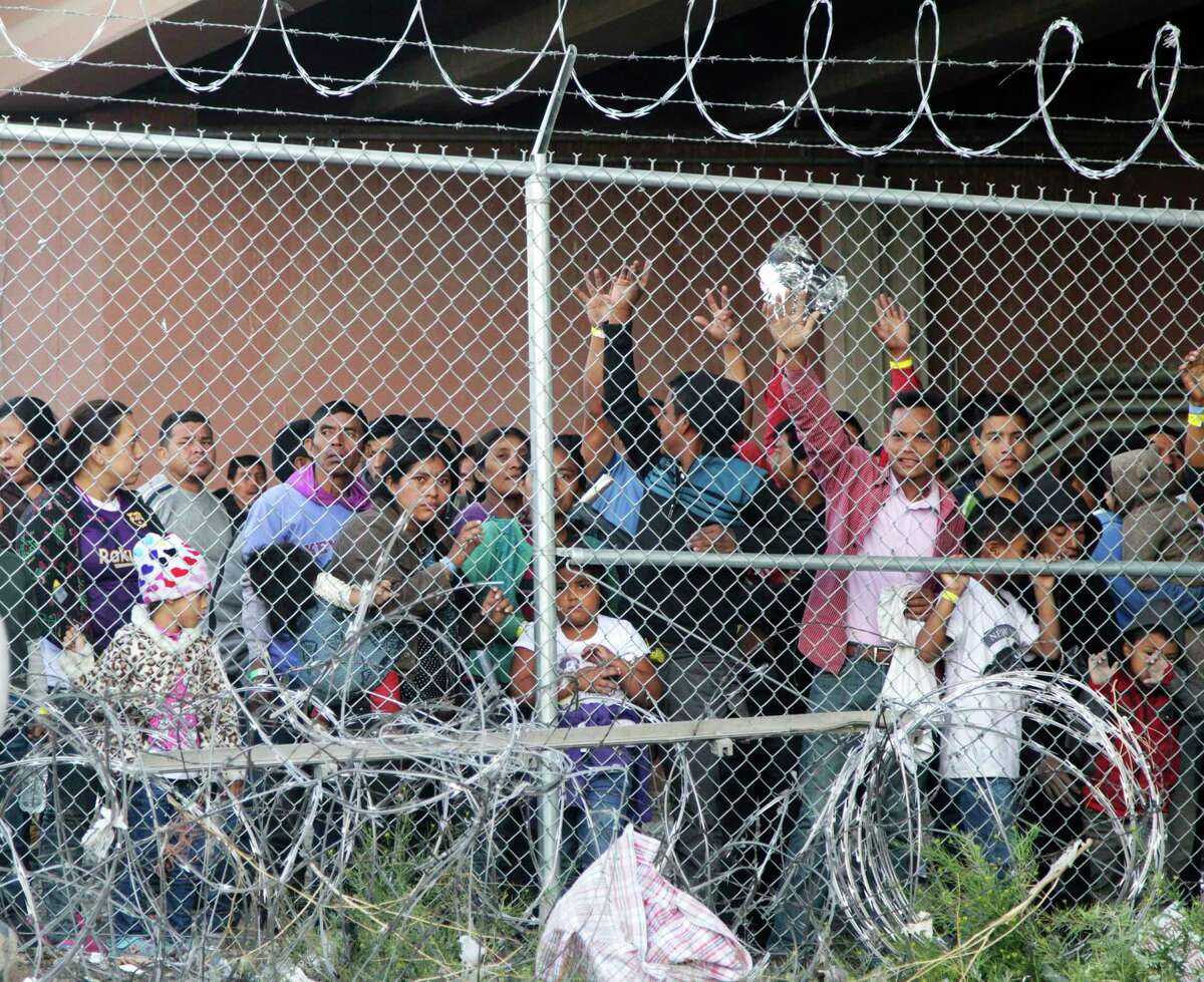 FILE - In this March 27, 2019, file photo, Central American migrants wait for food in a pen erected by U.S. Customs and Border Protection to process a surge of migrant families and unaccompanied minors in El Paso, Texas. Texas Gov. Greg Abbott says he's sending another 1,000 National Guard troops to the U.S.-Mexico border and blasted Congress as a "group of reprobates" over the growing humanitarian crisis. Abbott said Friday, June 21, 2019, that the additional Guard members will assist at detention facilities and at ports of entry. . (AP Photo/Cedar Attanasio, File)
