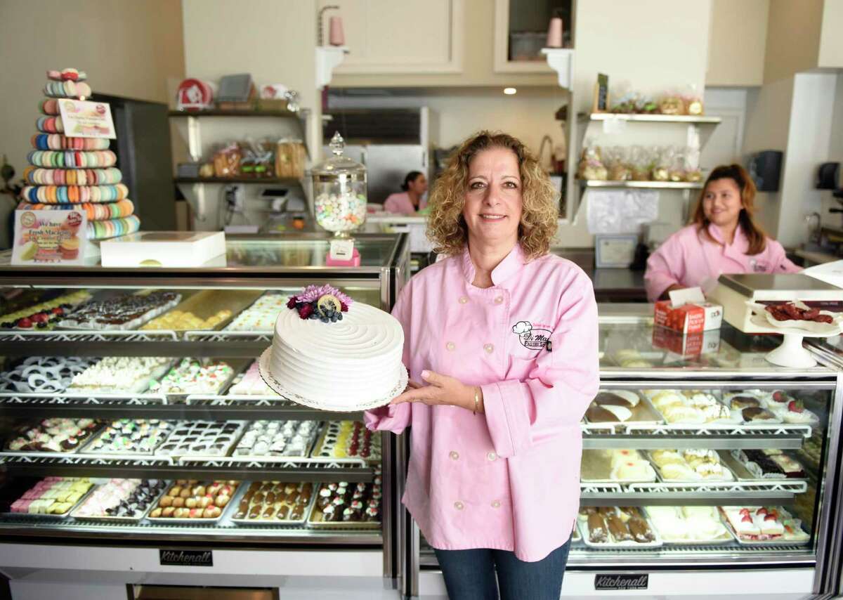 Owner Sabrina DiMare Taylor poses with a cake in the new location of DiMare Pastry Shop in the Riverside section of Greenwich, Conn. Thursday, June 27, 2019. The new DiMare location is directly behind the former location in the Riverside Commons shopping center. The shop moved to make way for Jersey Mike's sandwich shop, and to slightly downsize to cut back on expenses and workload.