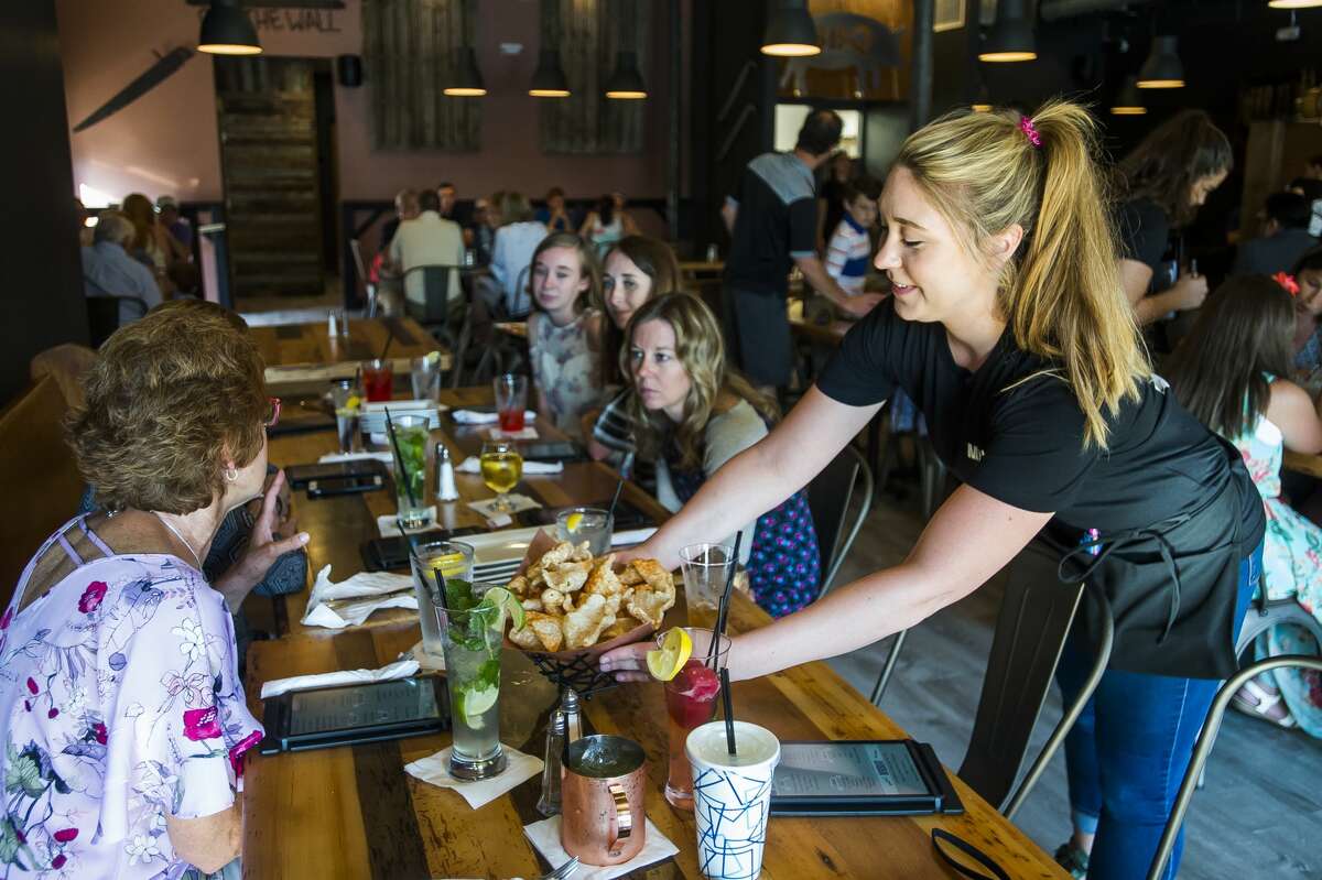 Staff of Molasses, the new smokehouse restaurant and bar opening this Sunday in downtown Midland, serve dinner for friends and family on Thursday, June 27, 2019. (Katy Kildee/kkildee@mdn.net)