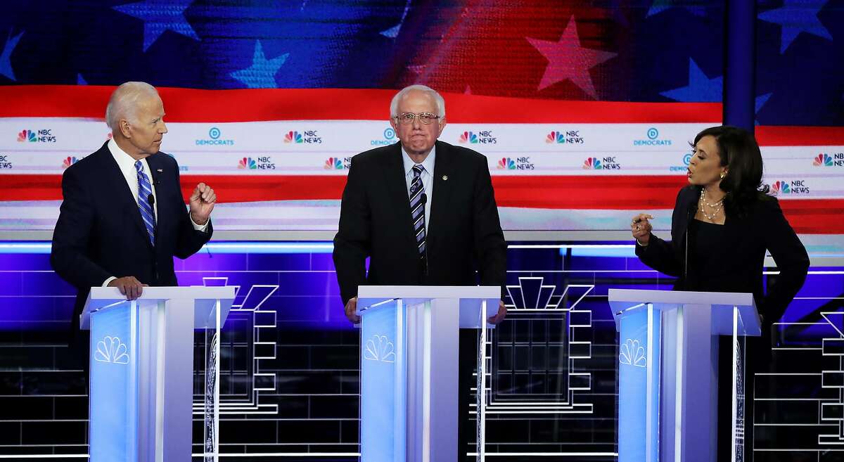 MIAMI, FLORIDA - JUNE 27: Sen. Kamala Harris (R) (D-CA) and former Vice President Joe Biden (L) speak as Sen. Bernie Sanders (I-VT) looks on during the second night of the first Democratic presidential debate on June 27, 2019 in Miami, Florida. A field of 20 Democratic presidential candidates was split into two groups of 10 for the first debate of the 2020 election, taking place over two nights at Knight Concert Hall of the Adrienne Arsht Center for the Performing Arts of Miami-Dade County, hosted by NBC News, MSNBC, and Telemundo. (Photo by Drew Angerer/Getty Images)