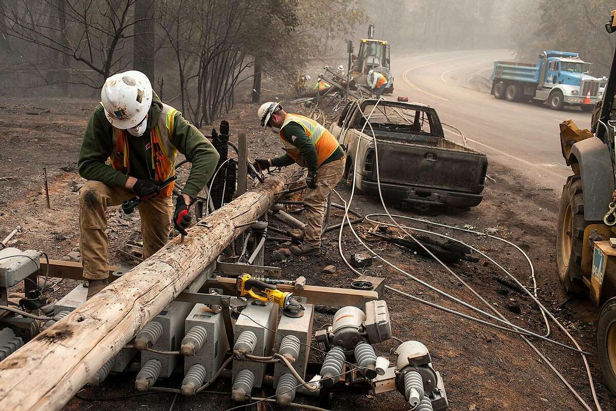 PG&E workers dissemble broken power lines after the Camp fire ripped through Paradise, Calif., on Nov. 15, 2018. Gov Gavin Newsom wants to extend an existing charge on utility customers' bills to generate billions for a new wildfire fund. (Joel Angel Juarez/Zuma Press/TNS)