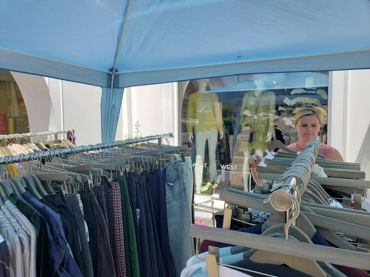 West store manager Brie McCormack tidies up the racks during the annual Westport Sidewalk Sale throughout Main Street, Post Road and areas surrounding downtown on June 28, 2019.