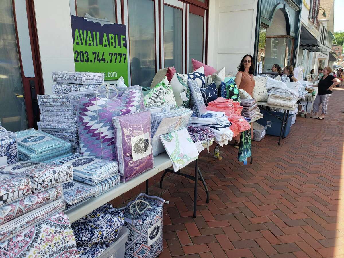 Brenda Donnelly helps out Fig Fine Linens during during the annual Westport Sidewalk Sale throughout Main Street, Post Road and areas surrounding downtown on June 28, 2019.