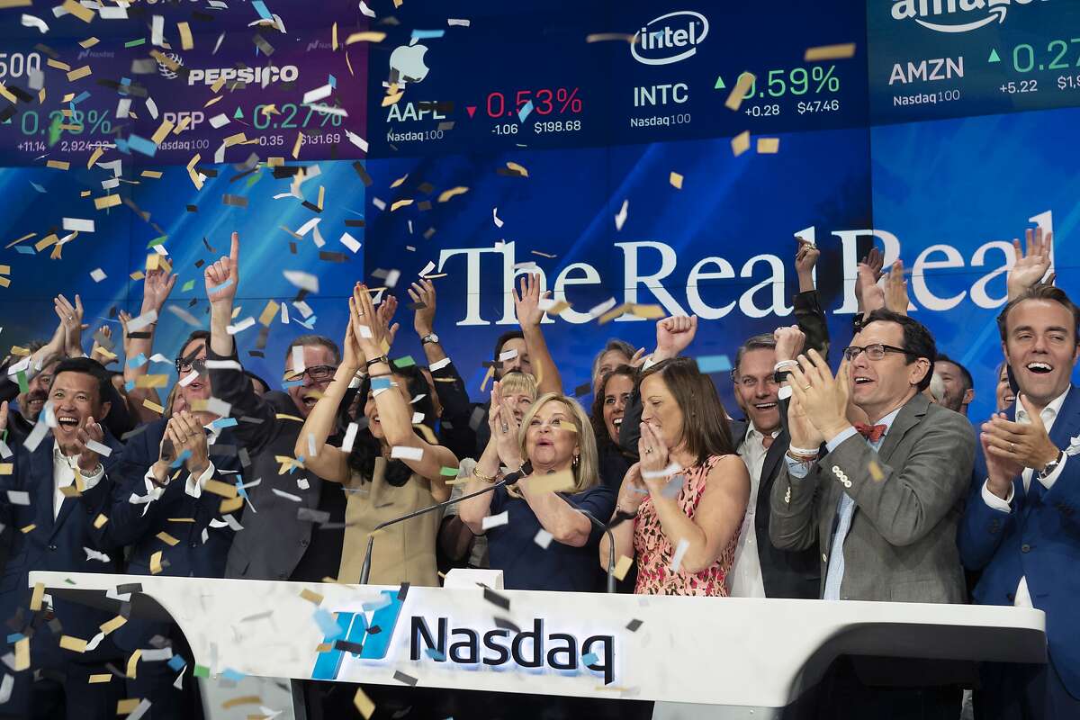 Julie Wainwright, center, CEO of The RealReal, celebrates her company's IPO at the Nasdaq opening bell, Friday, June 28, 2019 in New York. The online reseller of luxury brand clothing and accessories is based in San Francisco. (AP Photo/Mark Lennihan)