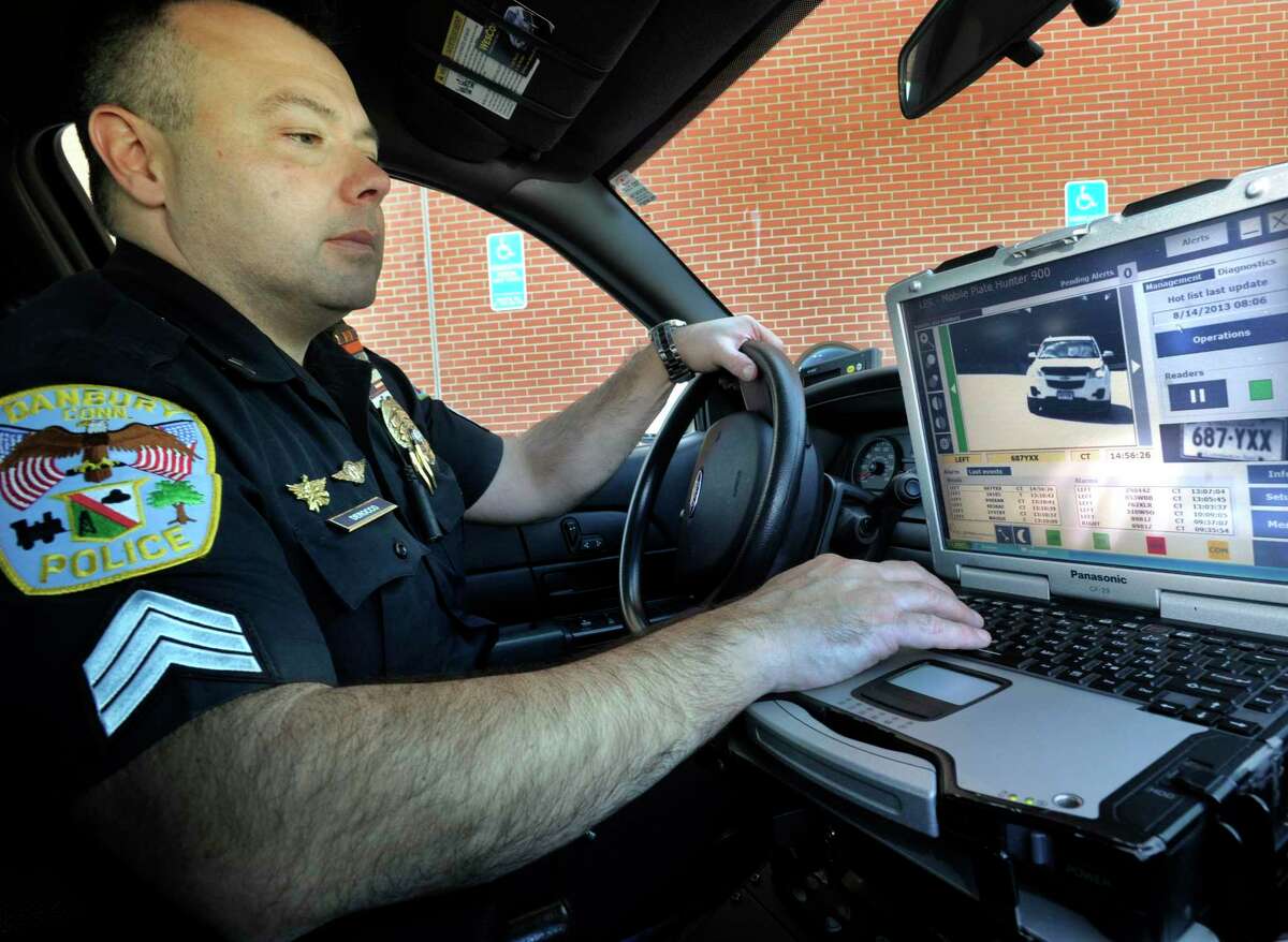 Danbury Police Sgt. Rory DeRocco, looks at the computer image of a car and data gathered by the license plate cameras attached to his patrol car on Aug. 14, 2013.