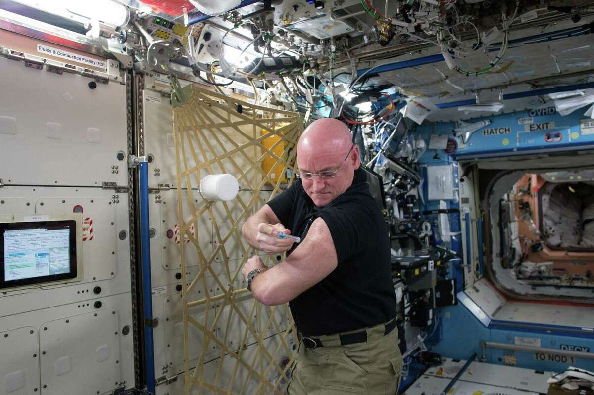 NASA astronaut Scott Kelly gives himself a flu shot for a study on the human immune system.