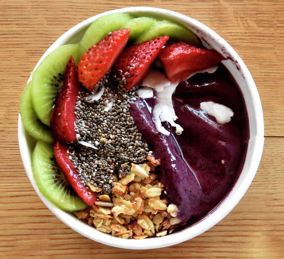 Madison, Connecticut - Friday, June 28, 2019: "Kiwi's Playhouse" is an acai bowl whose ingredients include a blend of acai, blueberries, mango pineapple, banana, lime, coconut water with toppings of kiwi, strawberries, chia seeds, granola, coconut, and honey and can be found at Life Bowls in Madison that offers Acai bowls, smoothies and fine coffee. Acai bowls have blended Acai berries from Brazil that is known to have a high content of antioxidants and no sugar.