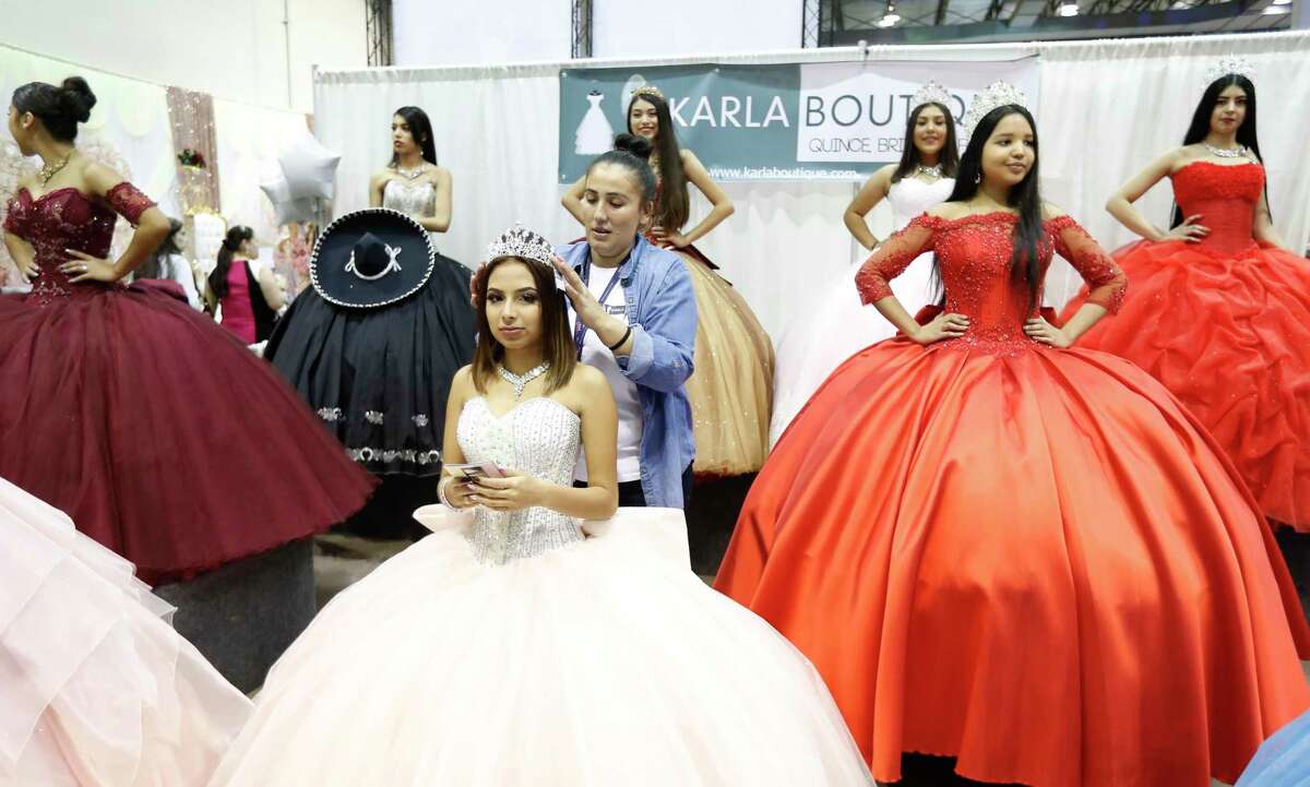A model in a quinceanera gown gets her tiara adjusted in the Karla Boutique booth at the annual Quince Expo at NRG Arena.