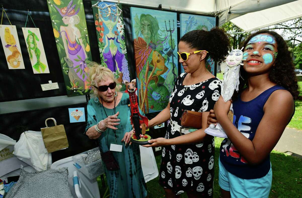 Visitors to Mathews Park including Andrea Johnstone and her daughter Cana Johnstone, 10, buy some art from artist Antoinette Campbell-Hunter during the Norwalk Arts Festival Saturday, June 29, 2019, in Norwalk, Conn.The Norwalk Art Festival features the works of 125 juried artists from local to national talent. They will exhibit a wide variety of media including, photography, drawing, ceramics, jewelry, painting, mixed media, printmaking, fiber, metal sculpture and glass. The festival continues Sunday from 12- 5pm