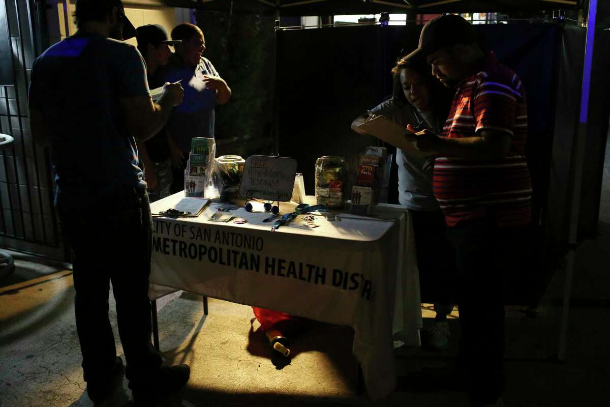 With help from intern Mercedes Medina, 22, people sign up for free HIV/syphilis testing at a San Antonio Metropolitan Health District mobile site in front of the Pegasus Night Club in 2017.