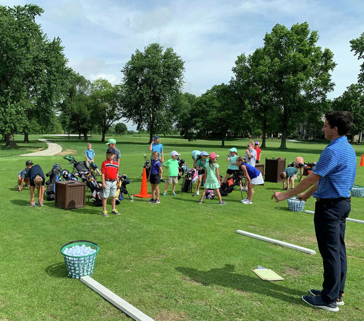 Nick Jones, right, assistant PGA professional at Sunset Hills Country Club, works with young golfers during a training session for the PGA Junior Golf League.