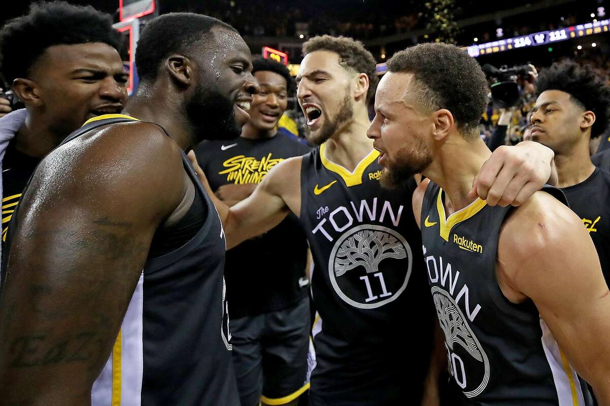 OAKLAND, CALIFORNIA - MAY 16: Stephen Curry #30, Klay Thompson #11 and Draymond Green #23 of the Golden State Warriors celebrate after defeating the Portland Trail Blazers 114-111 in game two of the NBA Western Conference Finals at ORACLE Arena on May 16,