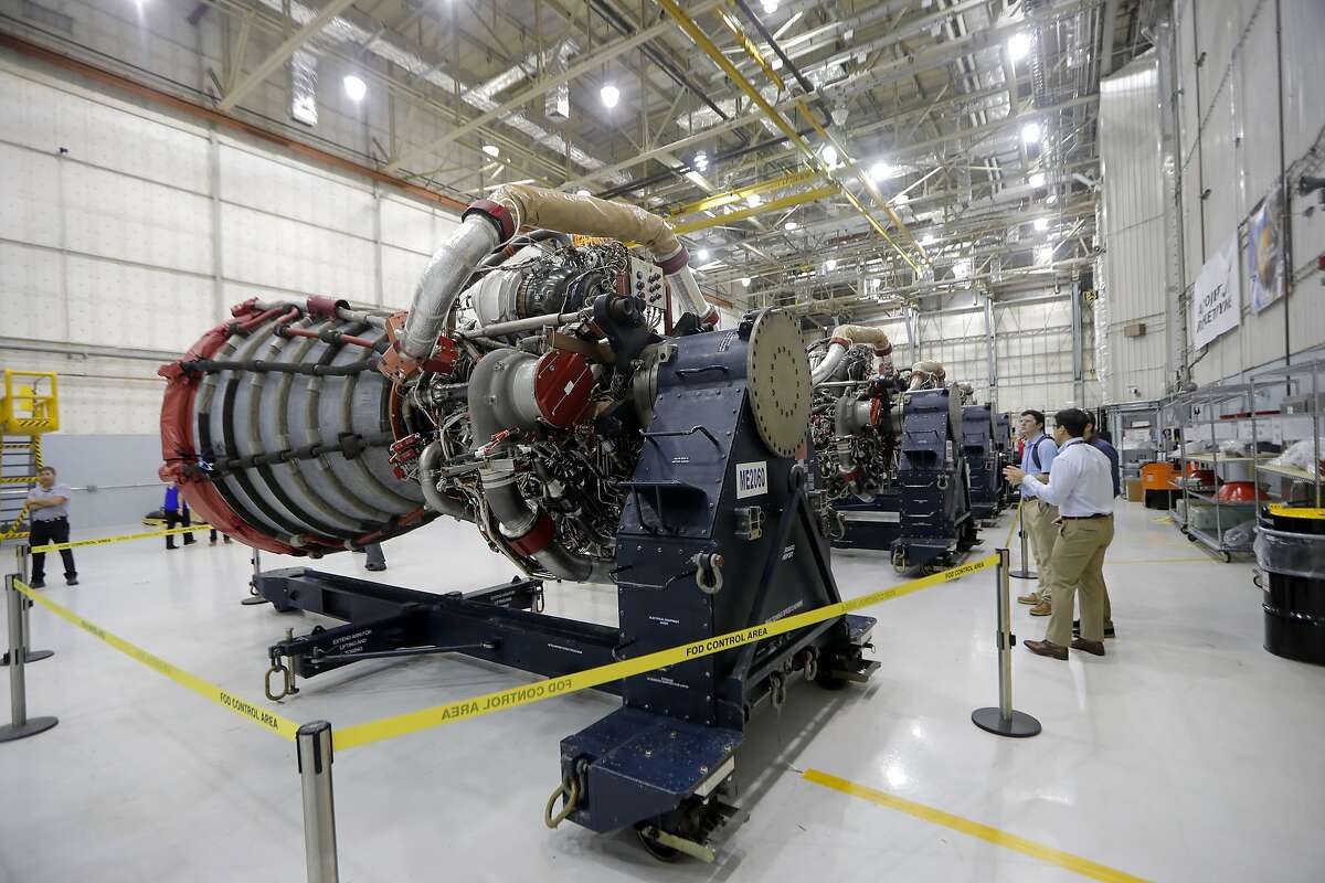Media and employees view four RS-25 engines, formerly used for space shuttle missions, that will be used for the core stage of NASA's Space Launch System (SLS), which they say will carry the Orion spacecraft, and ultimately a crew, to the moon and beyond, at the NASA Michoud Assembly Facility in New Orleans, Friday, June 28, 2019. (AP Photo/Gerald Herbert)