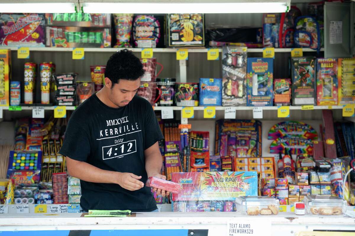 Axel Meza stocks shelves with fireworks at Alamo Fireworks on FM2252. Personal use of fireworks is illegal in the San Antonio city limits.