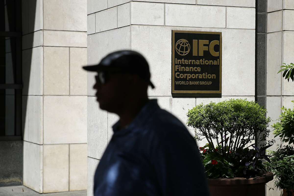 In this June 12, 2019, photo, a man walks past an entrance to the International Finance Corporation, a unit of the World Bank Group, in Washington. The unit of the World Bank has been dragged onto the edges of Latin America’s biggest corruption scandal involving a highway connecting the Colombian capital to busy Caribbean ports. (AP Photo/Patrick Semansky)