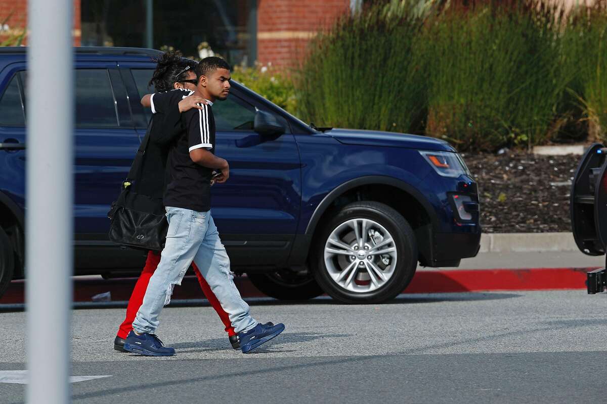 Marcelino Valiente walks with his mother Valerie Ortiz away from Tanforan hopping mall after a shooting on Tuesday afternoon, July 2, 2019, in San Bruno, California. Marcellino was in the theater at the time of the shooting