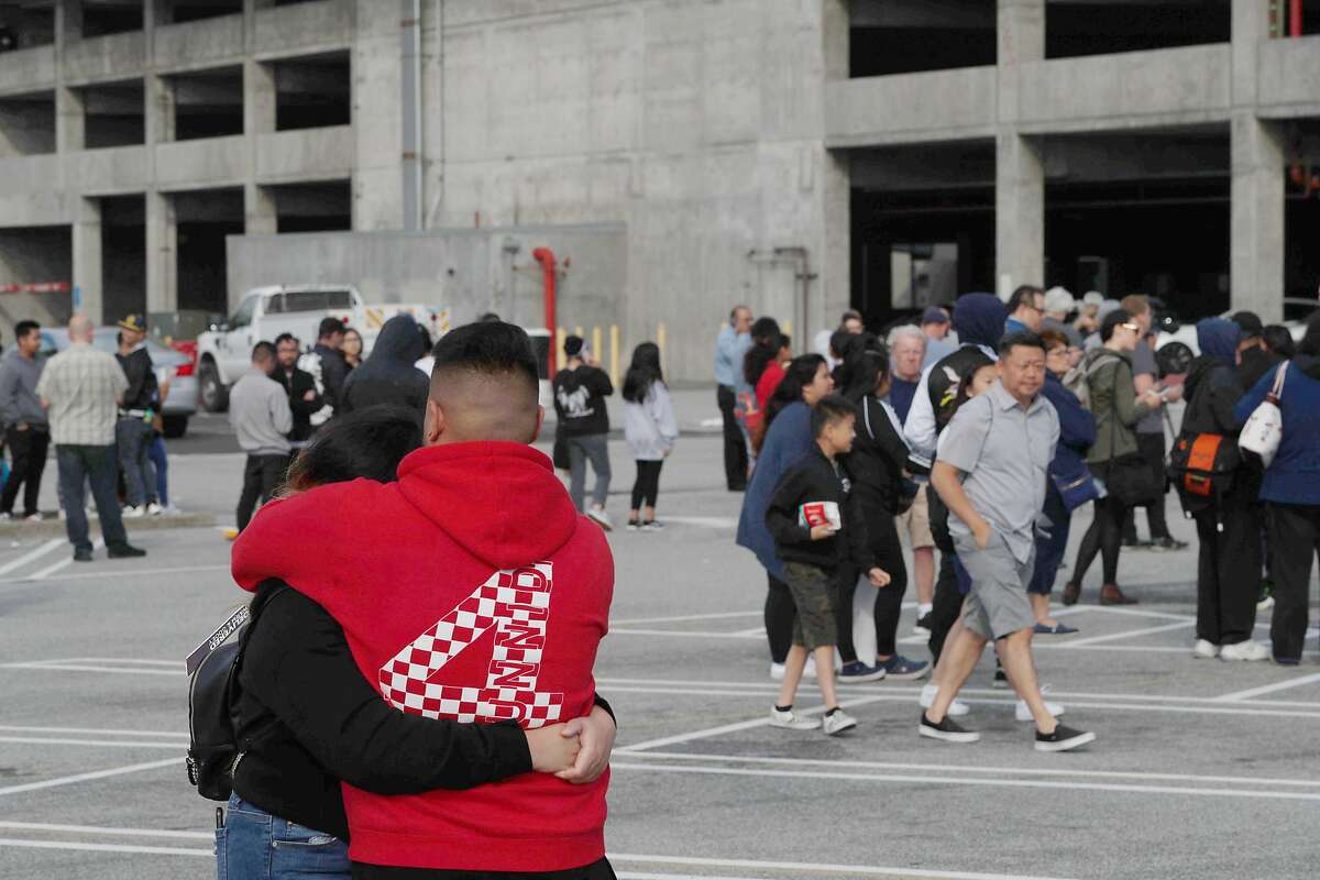 A couple, who wished to not be identified, embrace outside the Century Theaters building at the Tanforan shopping Mall following a shooting inside the mall on Tuesday, July 2, 2019, in San Bruno, California.