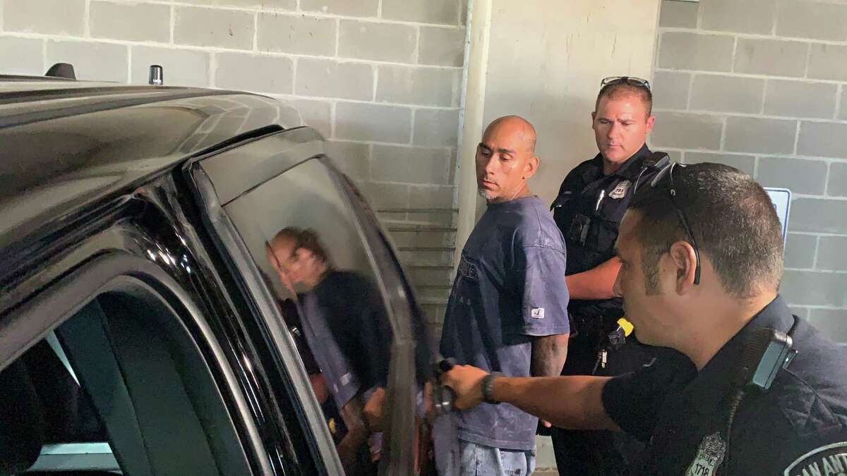 Paul Gutierrez, 42, is escorted to a police vehicle on his way to the Bexar County Jail on Tuesday. He was arrested earlier in the day on a charge of murder in connection with the January death of Edward Beltran, 36.