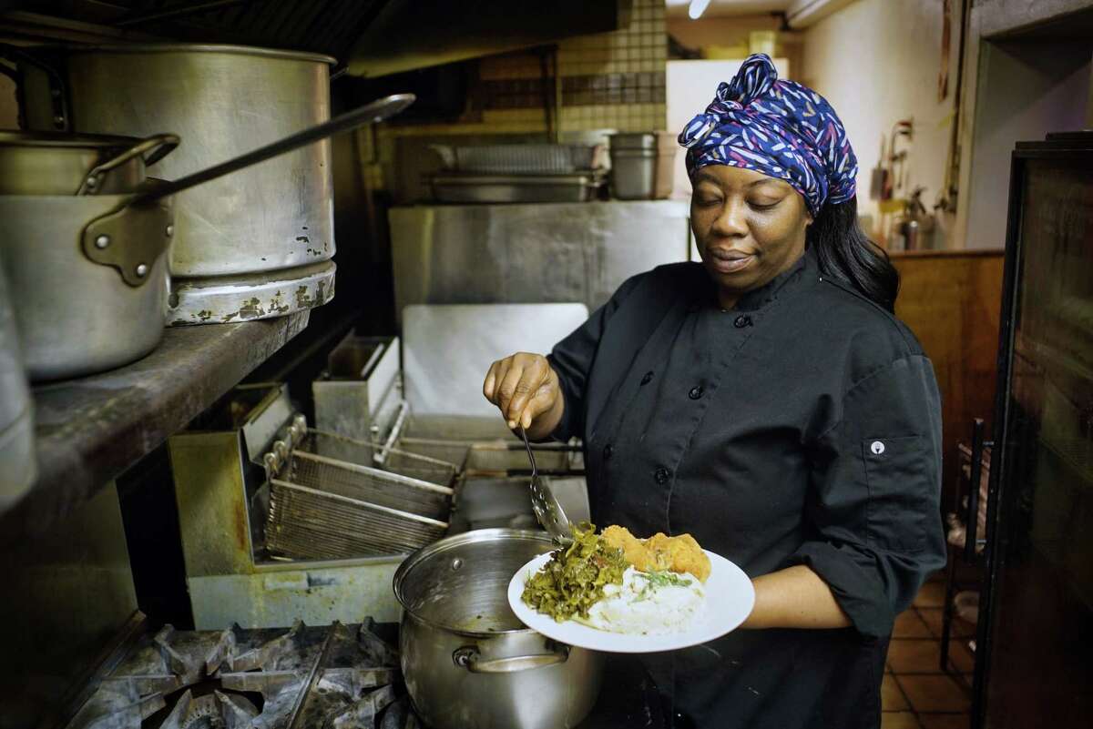 Kizzy Williams, owner of Allie B's Cozy Kitchen, puts collard greens on a plate in the kitchen on Tuesday, June 11, 2019, in Albany, N.Y. (Paul Buckowski/Times Union)