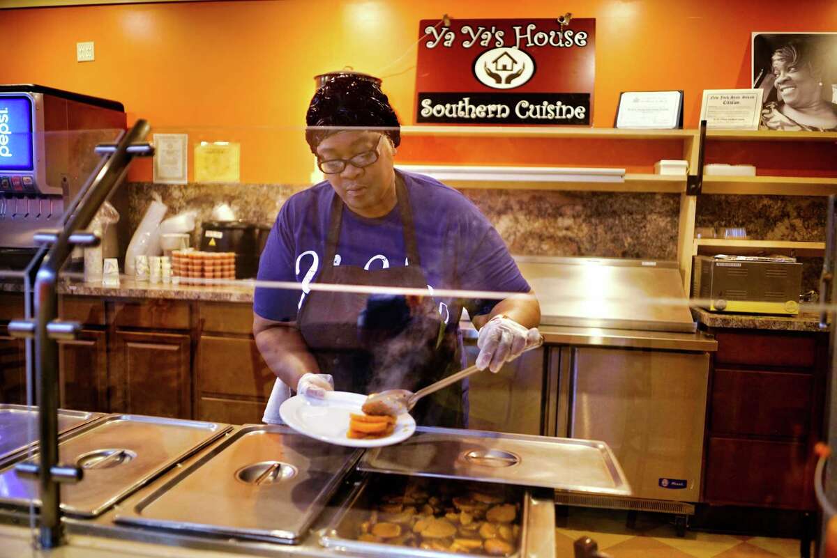 Amanda Thompson, owner of Ya-Ya's House, puts some sweet potatoes on a plate on Wednesday, June 19, 2019, in Schenectady, N.Y. (Paul Buckowski/Times Union)