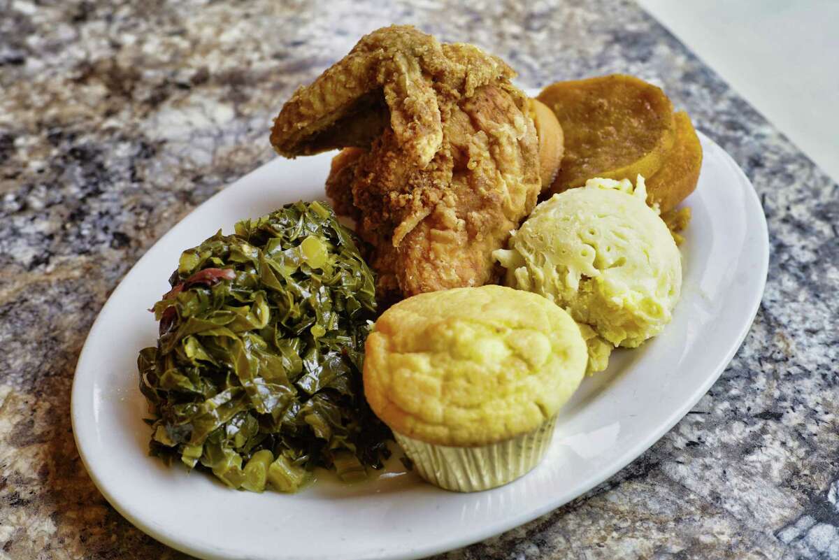 A view of a plate of collard greens, fried chicken, sweet potatoes, macaroni and cheese and a corn muffin at Ya-Ya’s House on Wednesday, June 19, 2019, in Schenectady, N.Y. 
