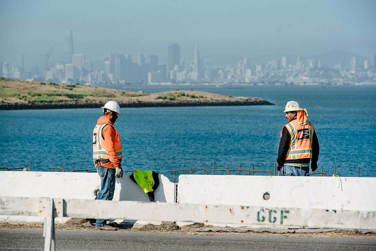 San Francisco is seen in the distance as workers with contractor Gordon N. Ball Inc. work on a section of the Bay Trail near Golden Gate Fields race track in Albany, Calif., on July 3rd, 2019.
