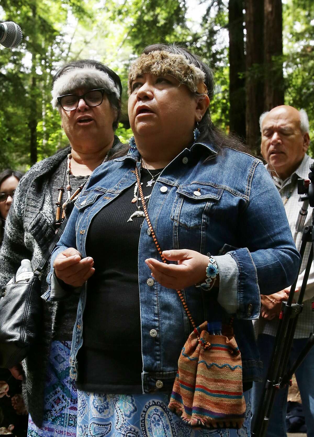 Representatives of the Amah Mutsun Tribal Band sing during the removal of the El Camino Real bell marker on Friday, 6/21, 2019 at UC Santa Cruz in Santa Cruz, California. From left are: Lorraine Luna, Catherine Luna and Valentin Lopez. The bell marker, which memorializes the California Missions and an imagined route of travel that once connected them, is viewed by the Amah Mutsun and many other California indigenous people as a racist symbol that glorifies the domination and dehumanization of their ancestors. It is being removed at the request of the Amah Mutsun, with support from UCSC faculty members, students, and administrators.