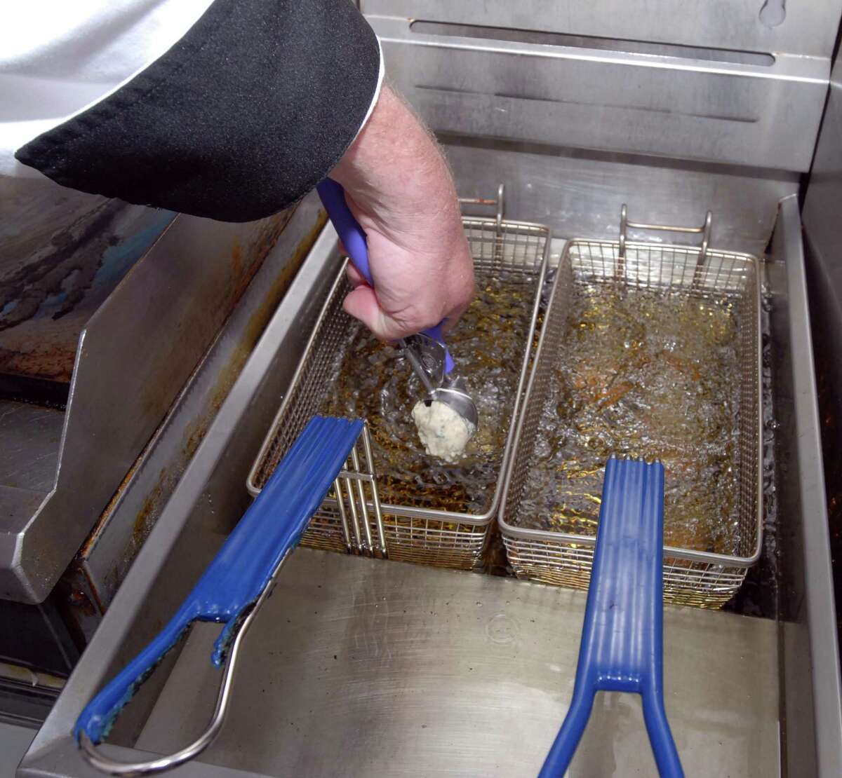 4/6/10 3Fritters ML0601B Joe Collier owner and executive chef of the Savin Rock Roasting Company drops a ball of clam fritter batter into the fryer at his West Haven restaurant. Photo by Mara Lavitt