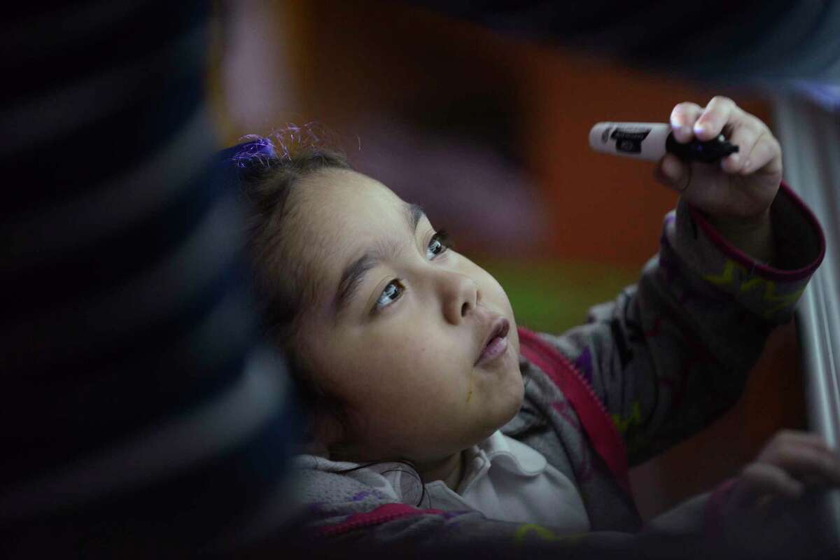 Abcde Rodriguez, 6, writes on a board under the watchful eye of special education teacher Veronica De Los Santos at Green Academy on Sept. 25, 2018.
