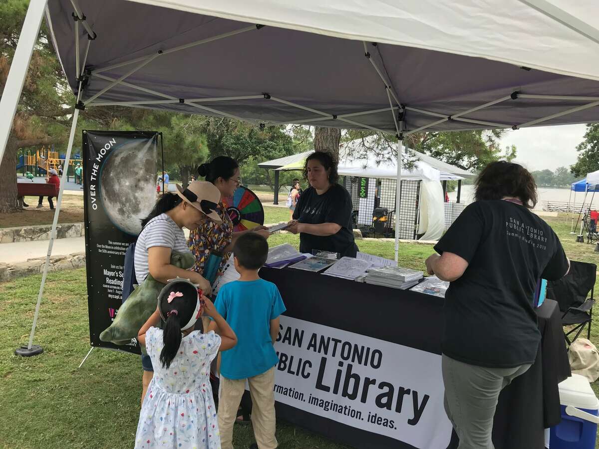 Julia Lazarin, early childhood services specialist for San Antonio Public Libraries, explains the Over the Moon summer reading program at the Woodlawn Lake Fourth of July celebration.